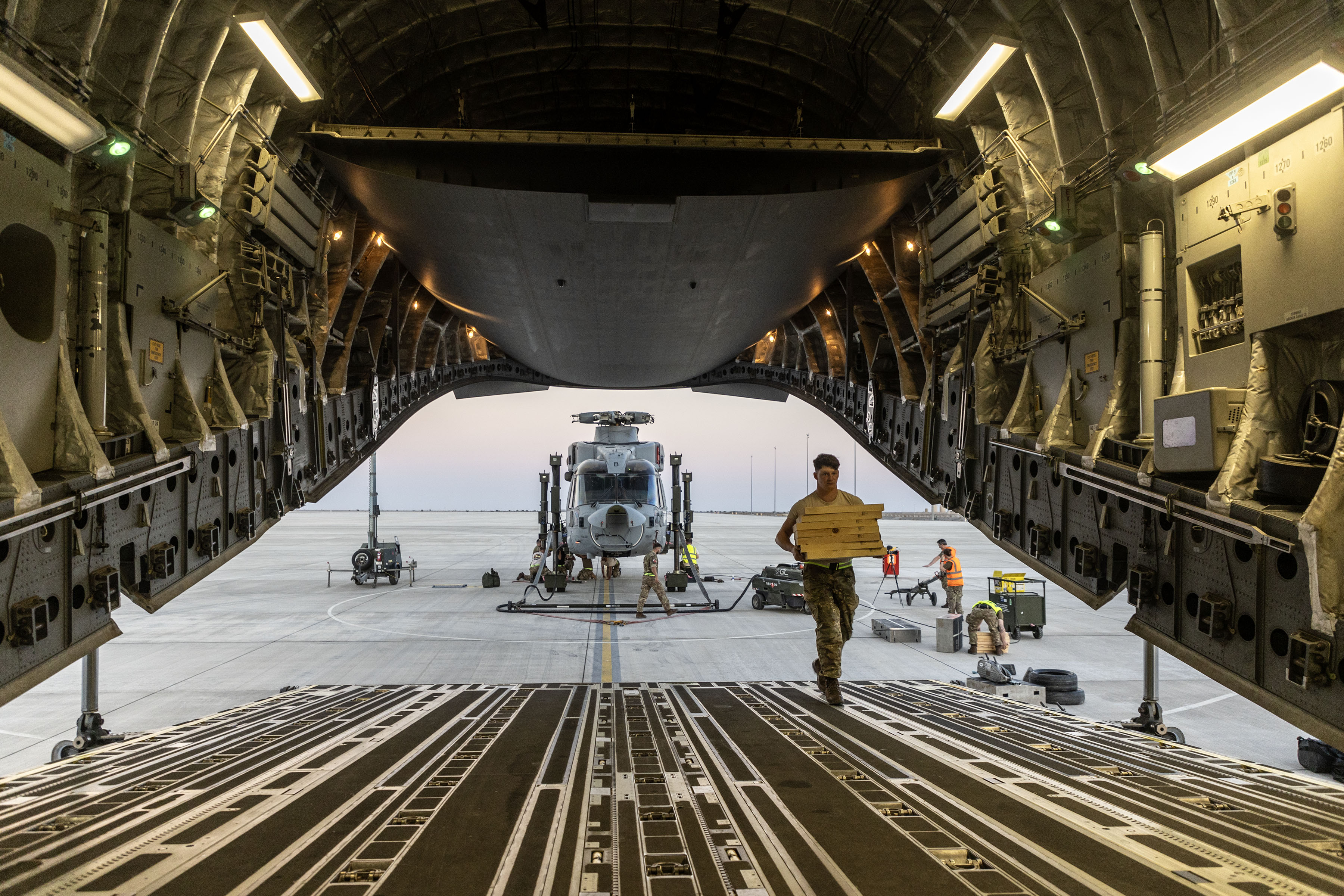 Photo - A view of the Merlin behind the RAF Globemaster aircraft, looking from inside the cargo bay, through the ramp and door